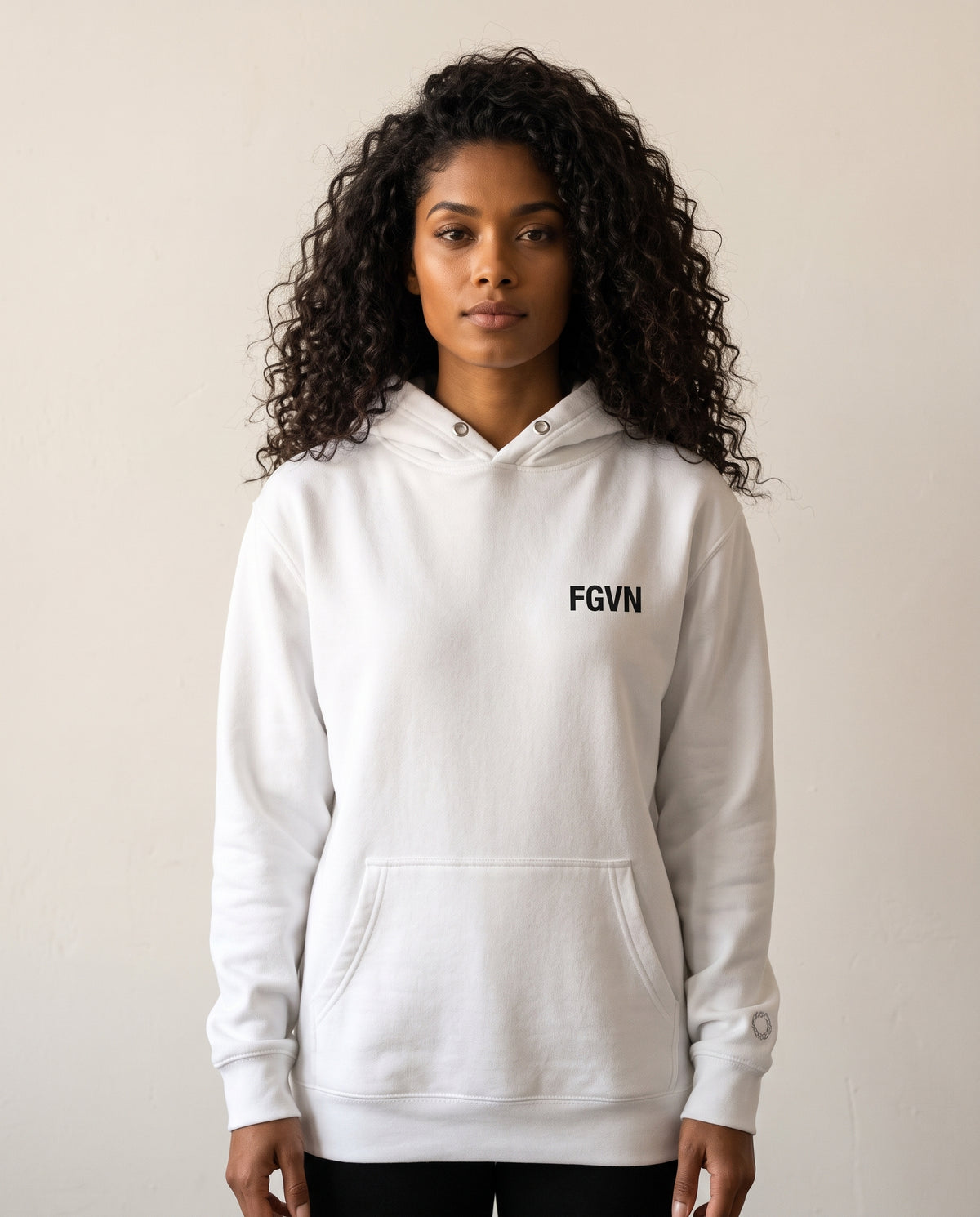 Emi wears a white hoodie in a front-facing photograph.